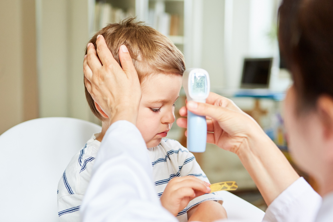 Pediatrician and Sick Child Measuring a Fever